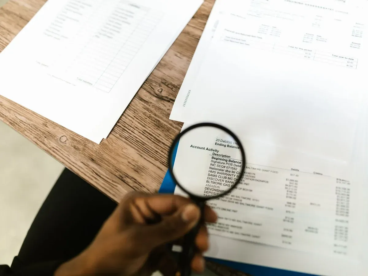 Consultant examinant un document à la loupe lors d'une revue d'audit