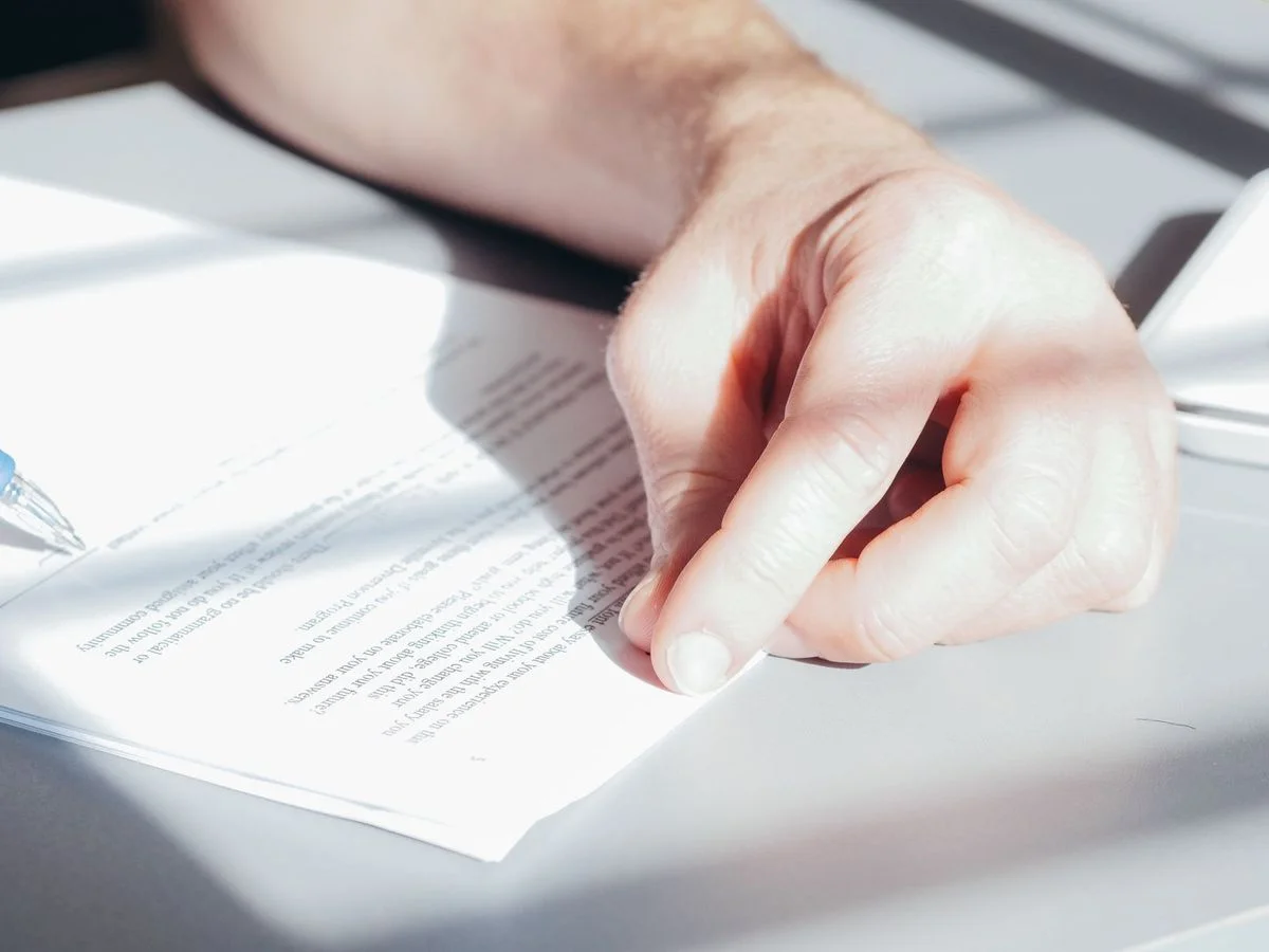 Formateur indépendant signant un document contractuel à son poste de travail