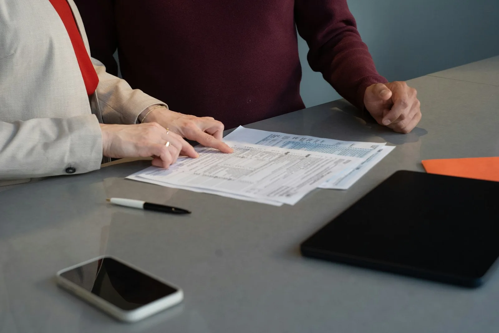 Deux personnes examinant des documents de conformité à une table