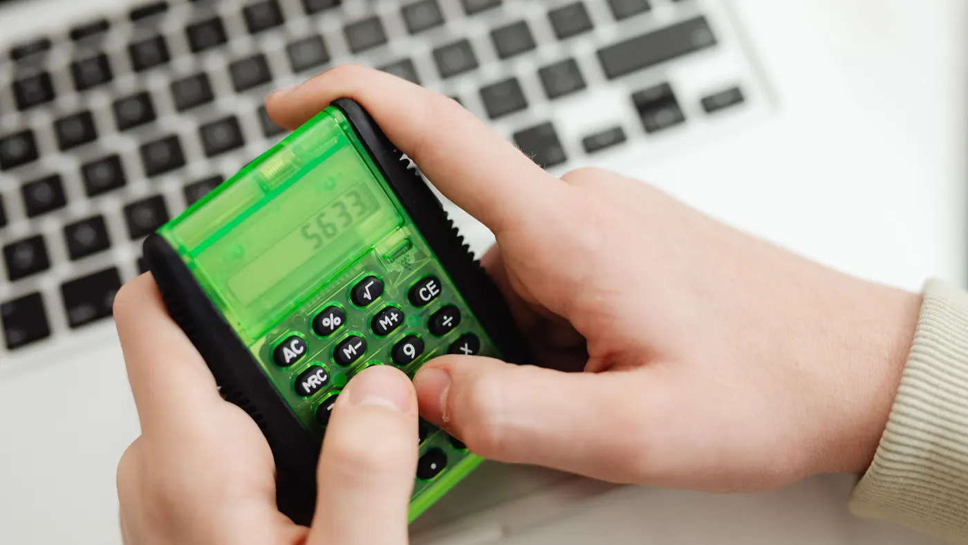 Personne utilisant une calculatrice pour estimer un budget de formation