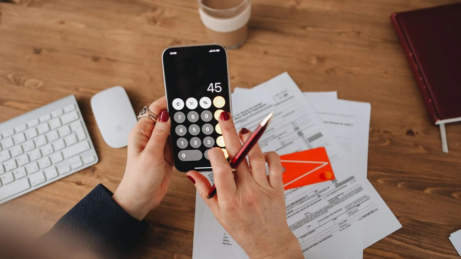 Mains tenant un smartphone affichant le mot budget, symbole du calcul du reste à charge d'une formation