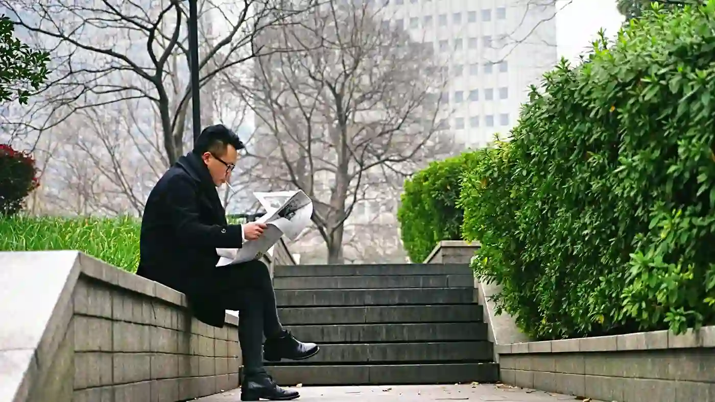 Homme lisant un journal, illustrant la veille de l'actualité réglementaire