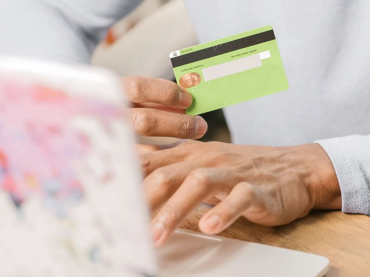 Personne tenant une carte bancaire pour un paiement lié au financement d'une formation