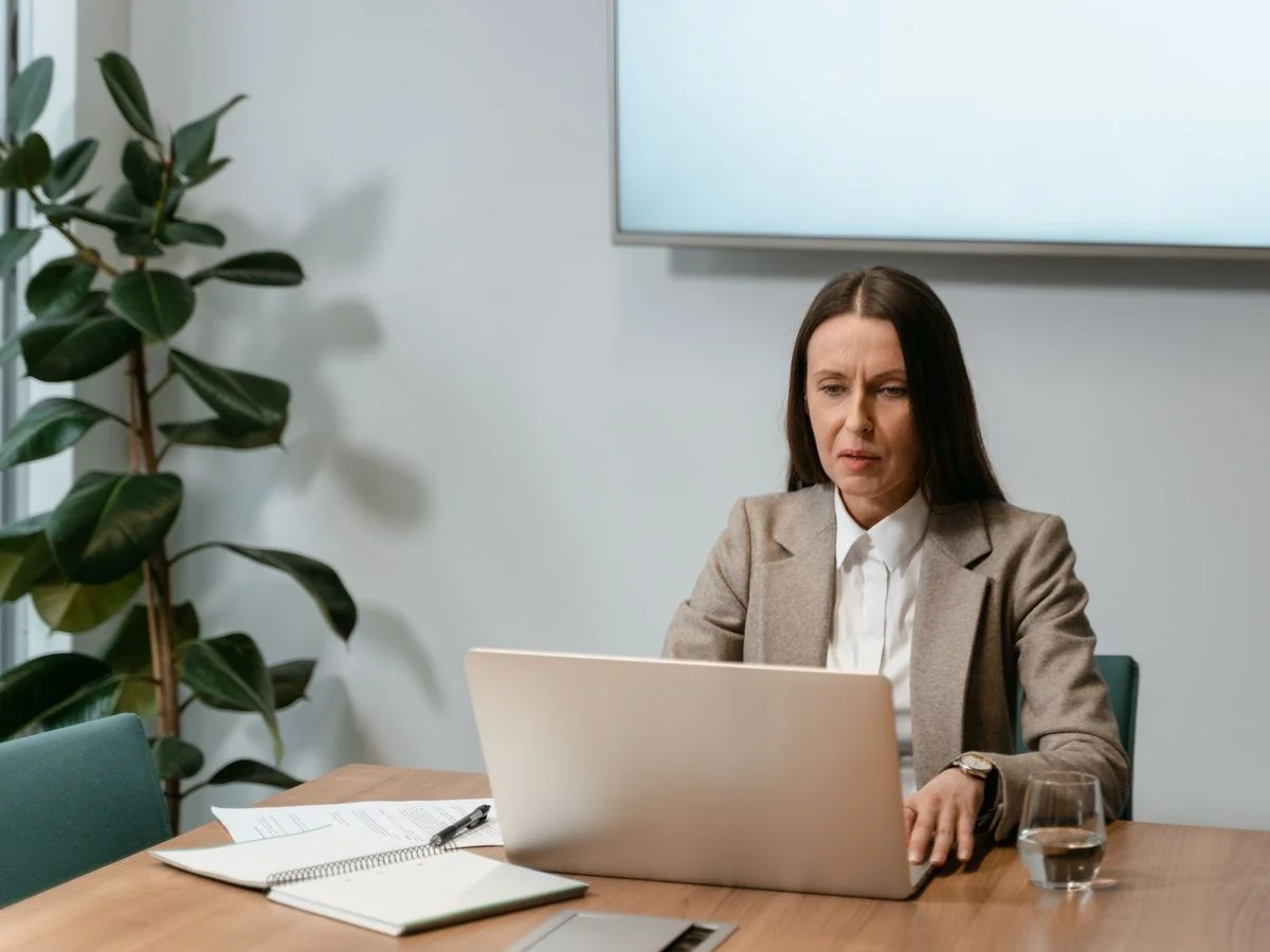 Formatrice utilisant un ordinateur pour consulter un outil numérique en contexte professionnel