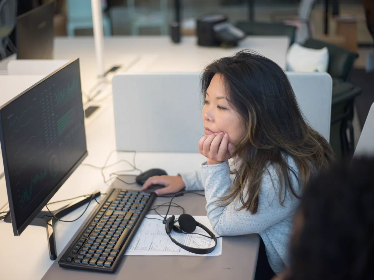 Collaboratrice analysant des données administratives sur un ordinateur de bureau