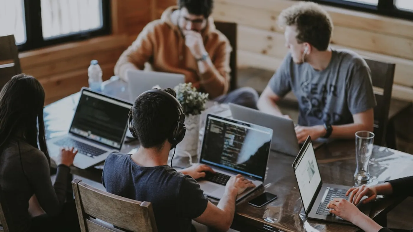 Équipe d'un organisme de formation collaborant autour d'outils numériques dans un espace de travail lumineux