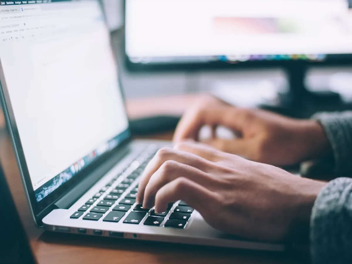 Personne suivant un parcours de formation en ligne sur ordinateur portable, tasse de café à côté