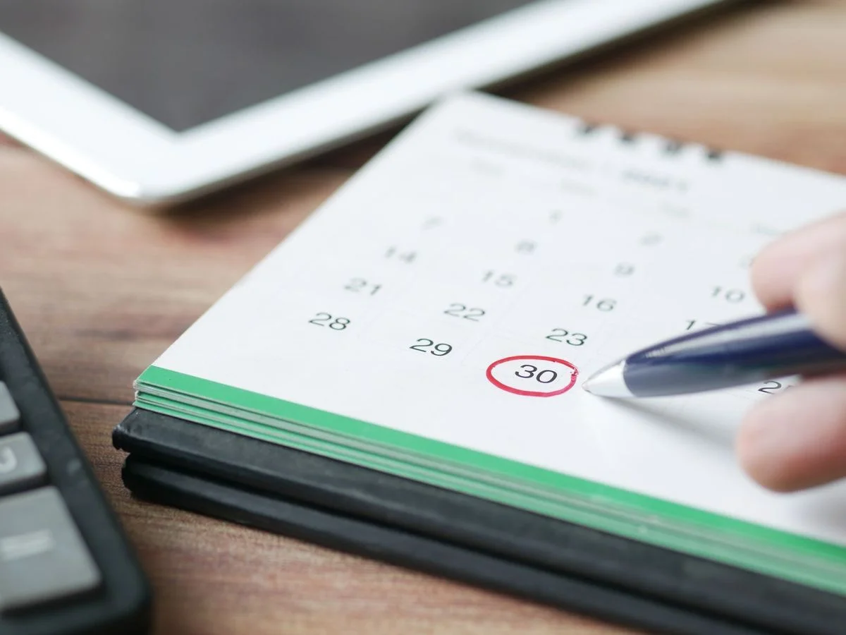 Gros plan sur un calendrier et un agenda de bureau, symbole d'une échéance réglementaire à anticiper