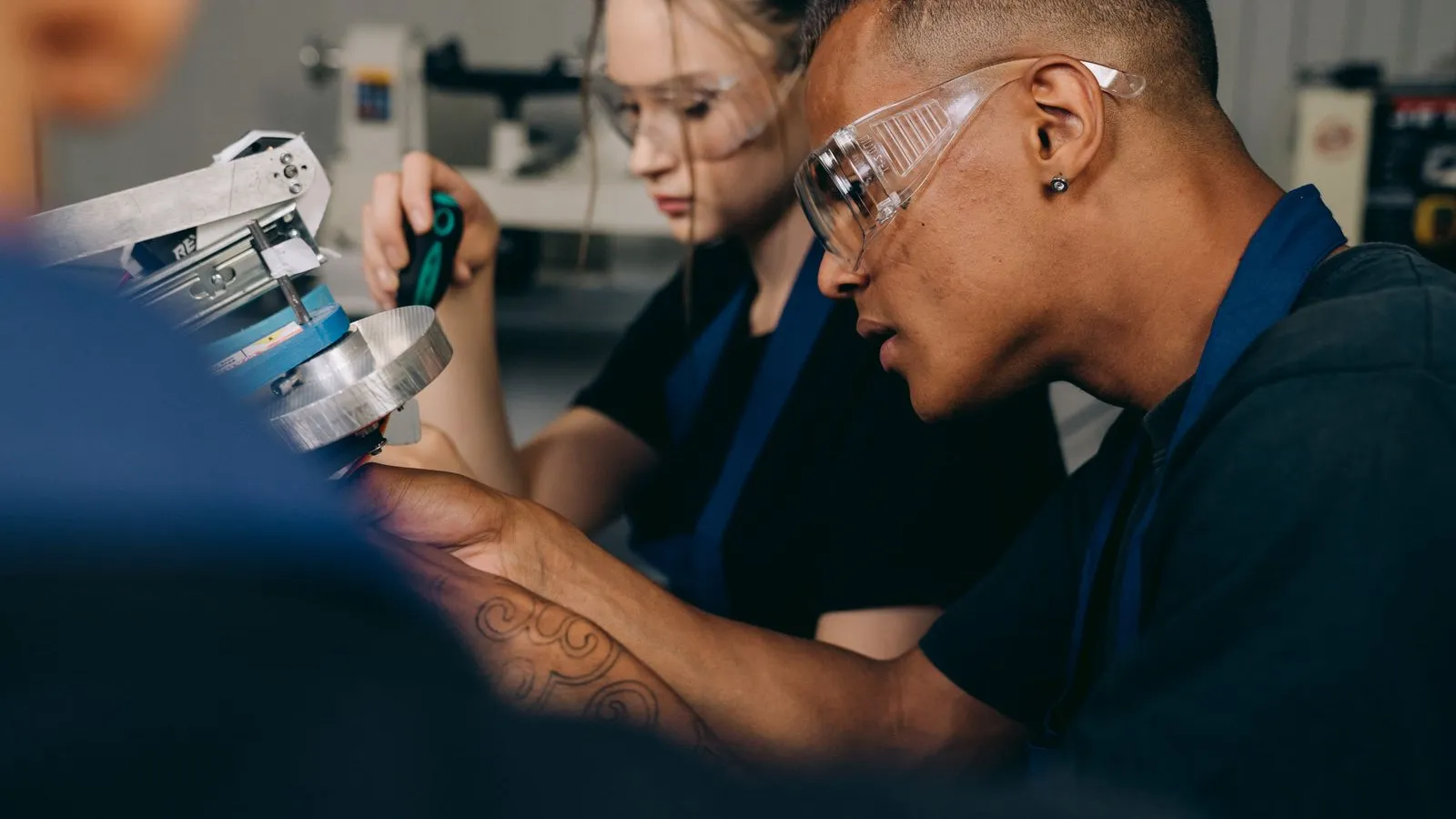 Apprenti en atelier de formation professionnelle encadré par un formateur