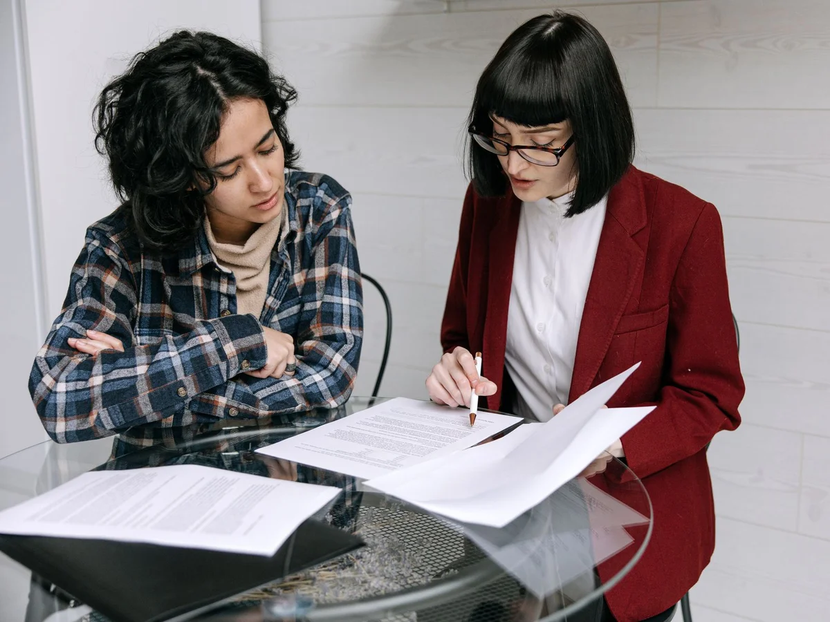 Contrôleur et responsable d'organisme de formation échangeant autour de documents lors d'un entretien