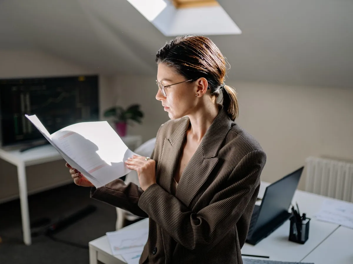 Responsable administratif consultant un courrier de notification et un dossier de formation au bureau