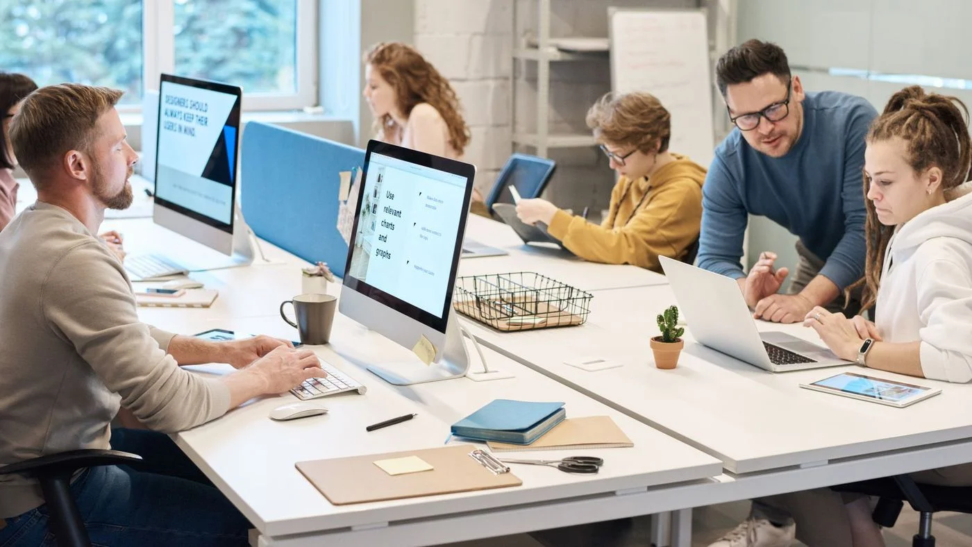 Espace de travail professionnel avec plusieurs collaborateurs sur ordinateur