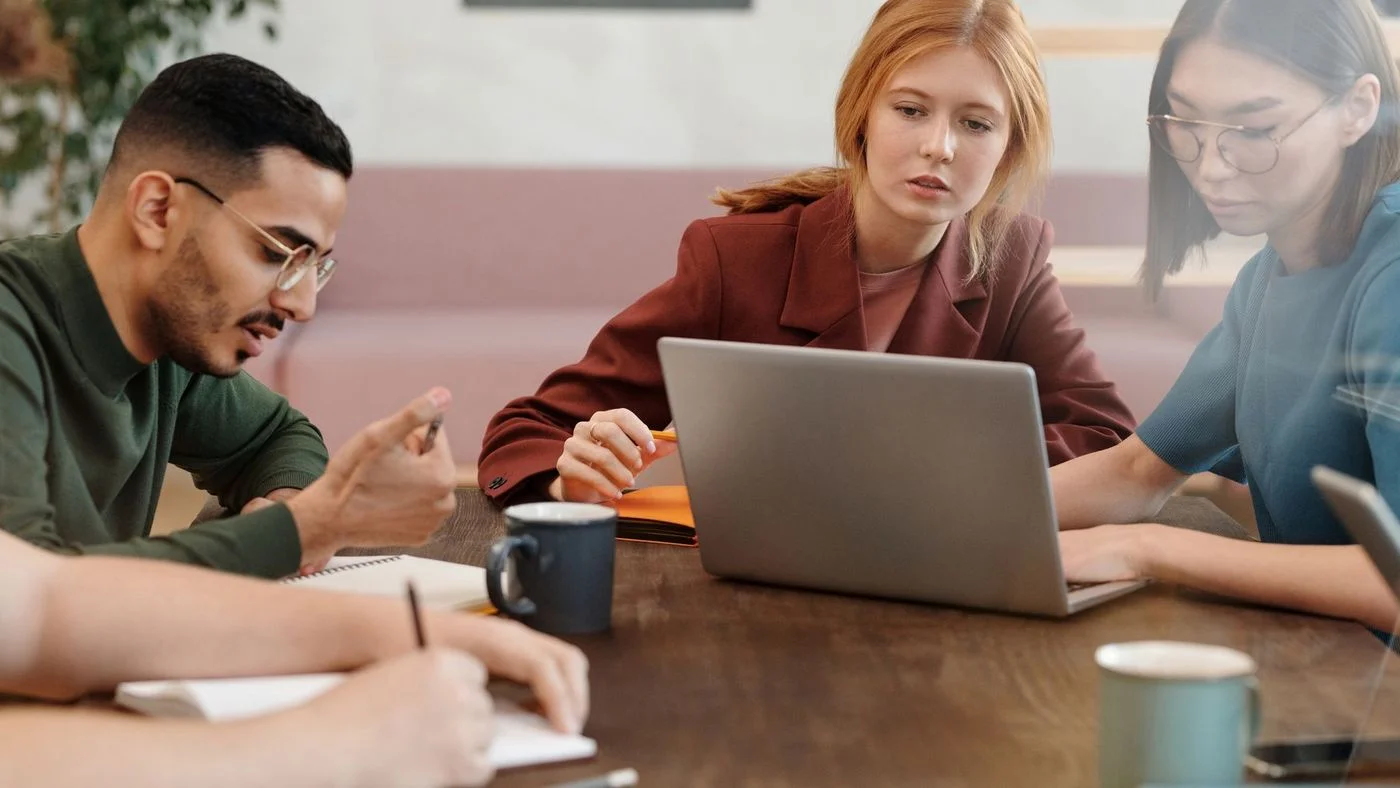 Équipe d'un organisme de formation travaillant ensemble sur le suivi de sa conformité qualité