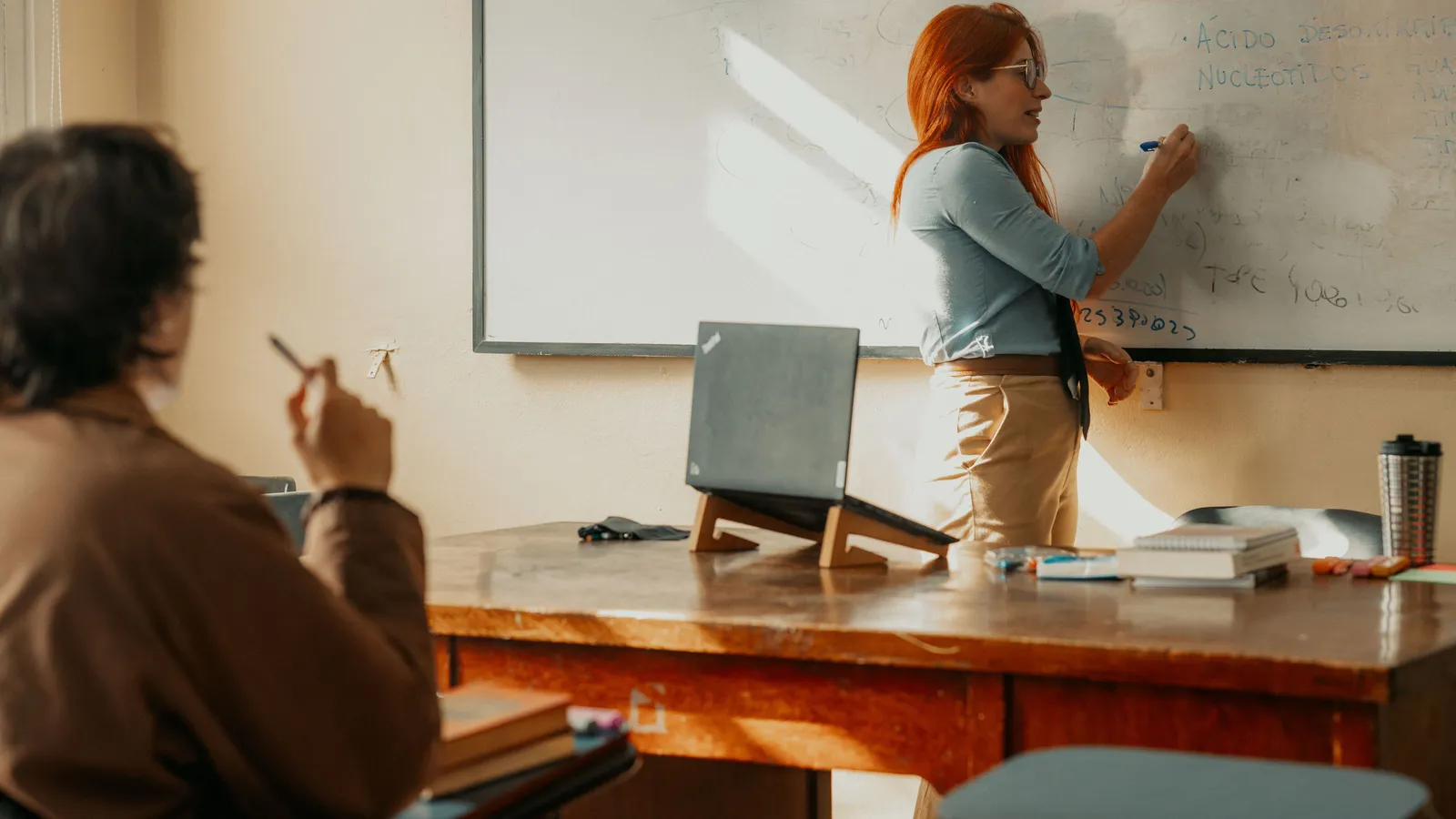 Formateur expliquant un concept pédagogique devant un groupe en salle de cours