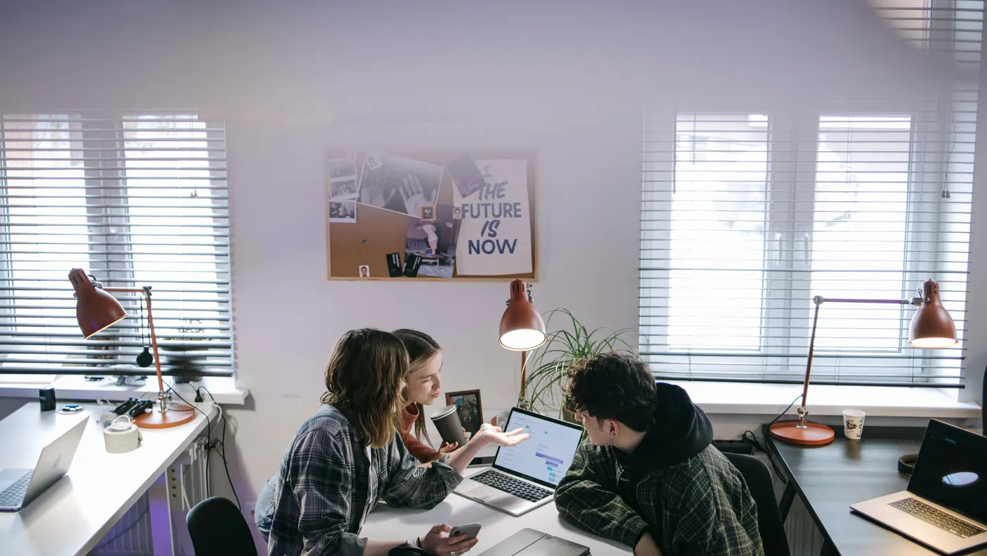Collègues collaborant autour d'un ordinateur portable dans un espace de travail professionnel
