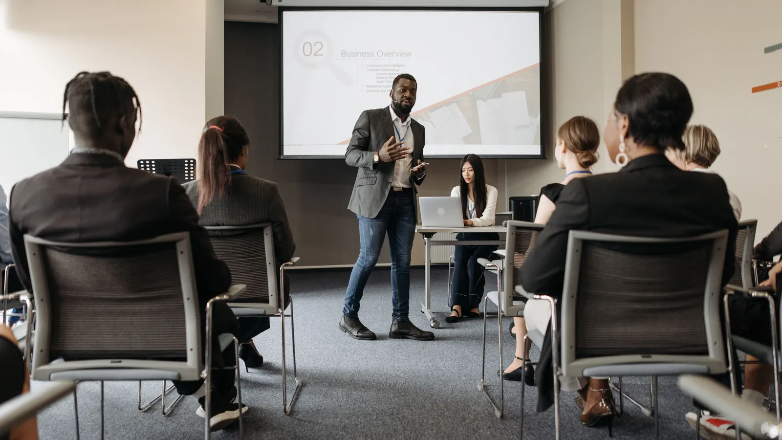 Formateur préparant un support de formation sur ordinateur portable, présentation et documents pédagogiques
