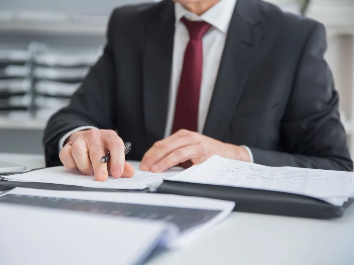 Chef d'entreprise consultant un dossier administratif de déclaration d'activité sur son bureau