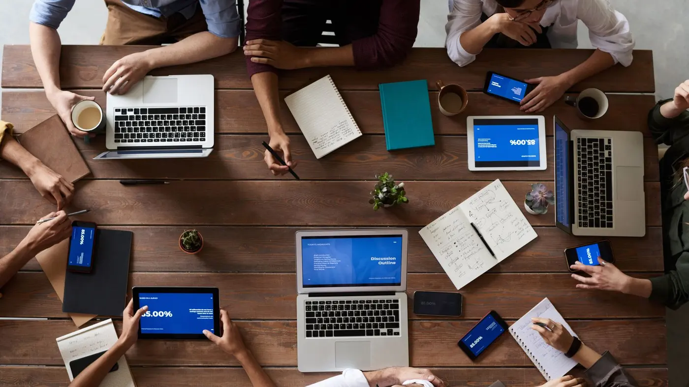 Espace de travail professionnel avec plusieurs écrans affichant des outils numériques et d'intelligence artificielle