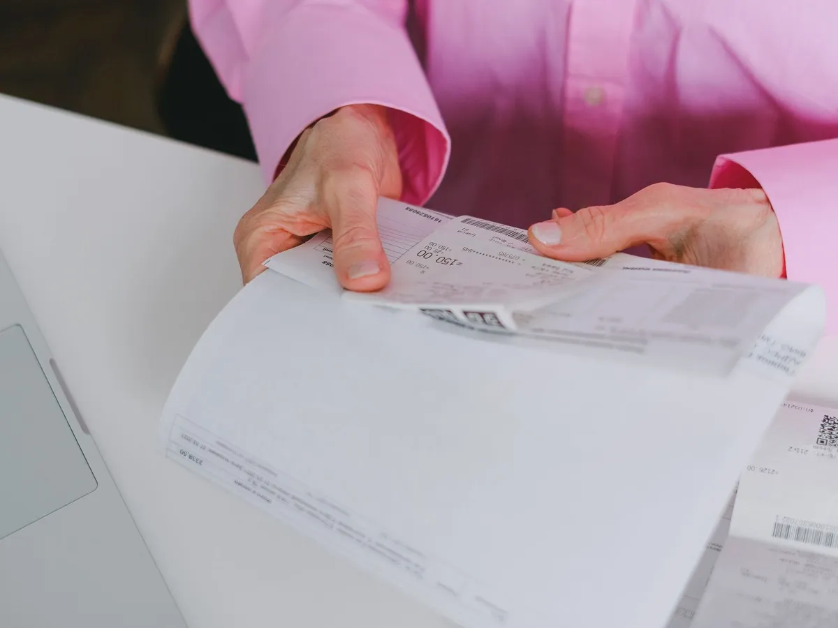 Gestionnaire administratif remettant une facture et un justificatif de virement bancaire