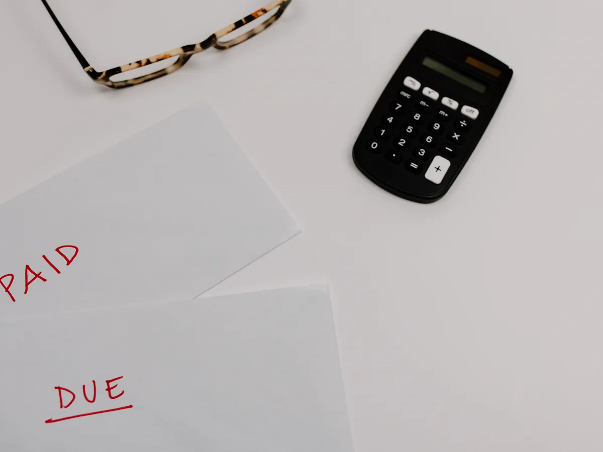 Calculatrice posée sur des factures lors du calcul d'un paiement OPCO