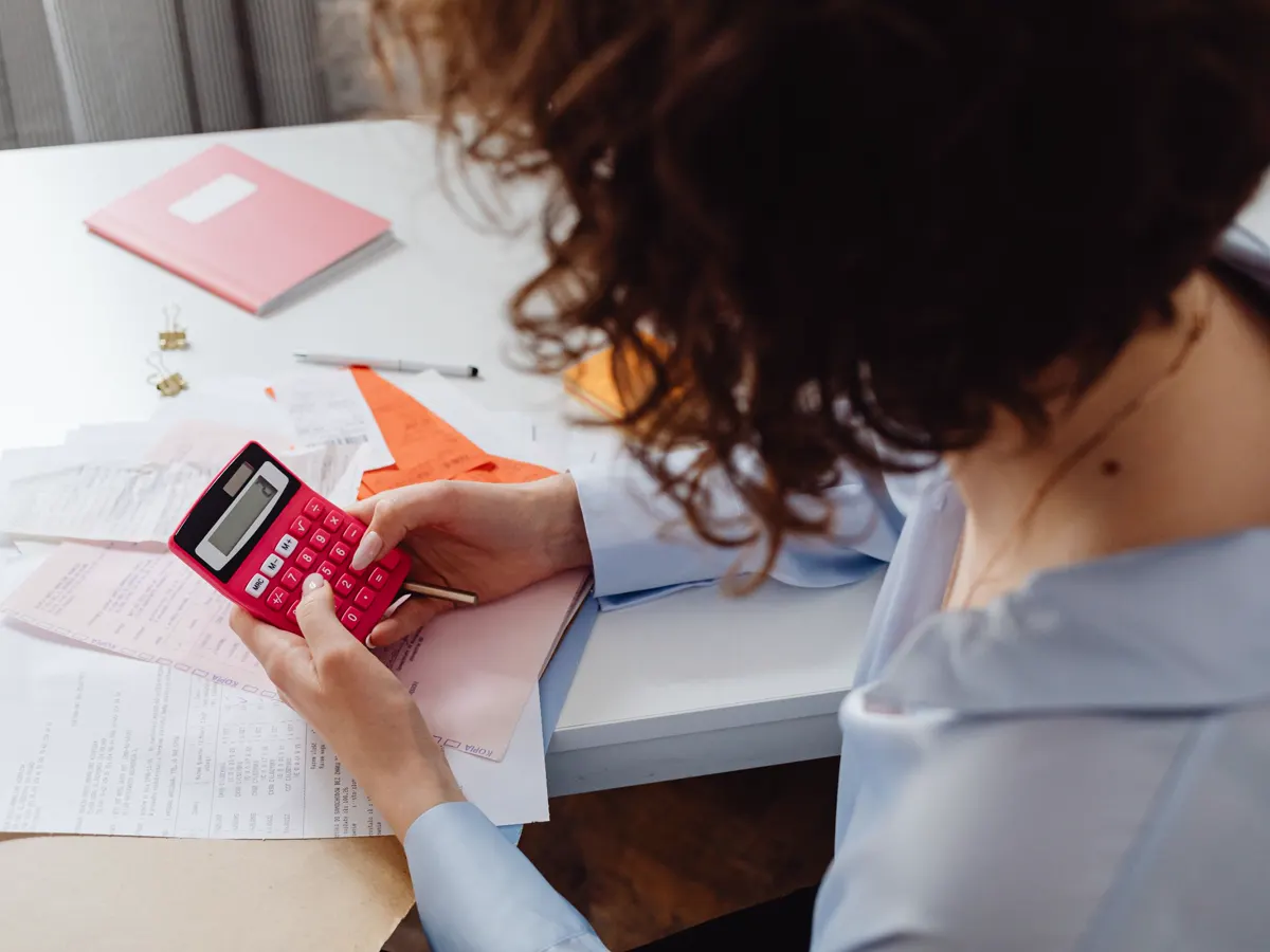 Chef d'entreprise de formation anticipant son budget avec une calculatrice avant la réforme TVA des OPCO