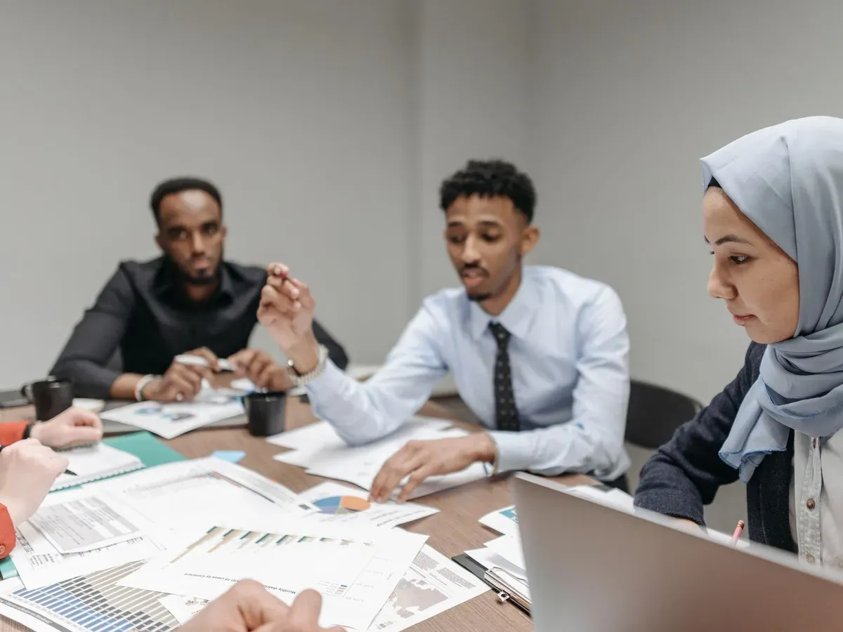 Réunion professionnelle comparant deux options d'organisation autour d'une table de travail