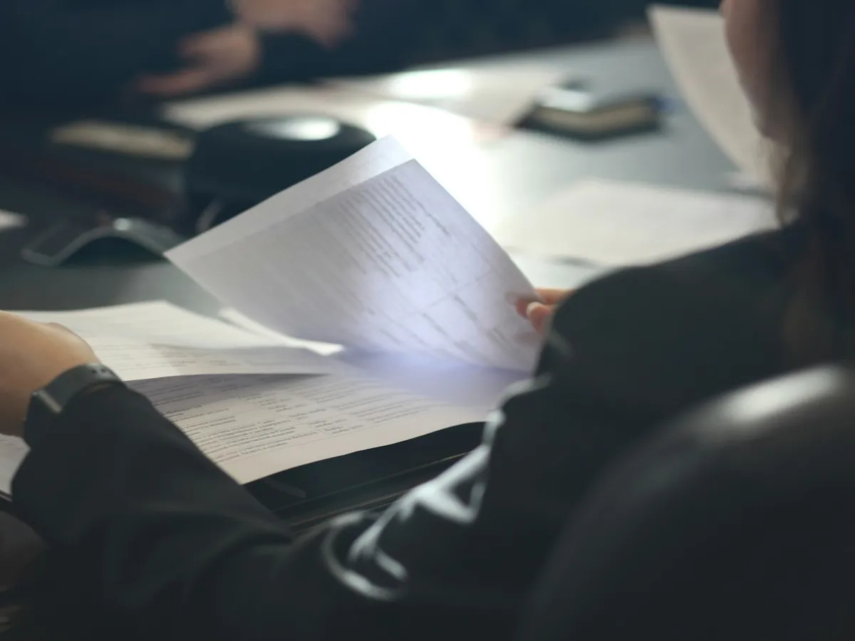 Personne analysant un document qualité à son bureau, dossier de preuves indicateur