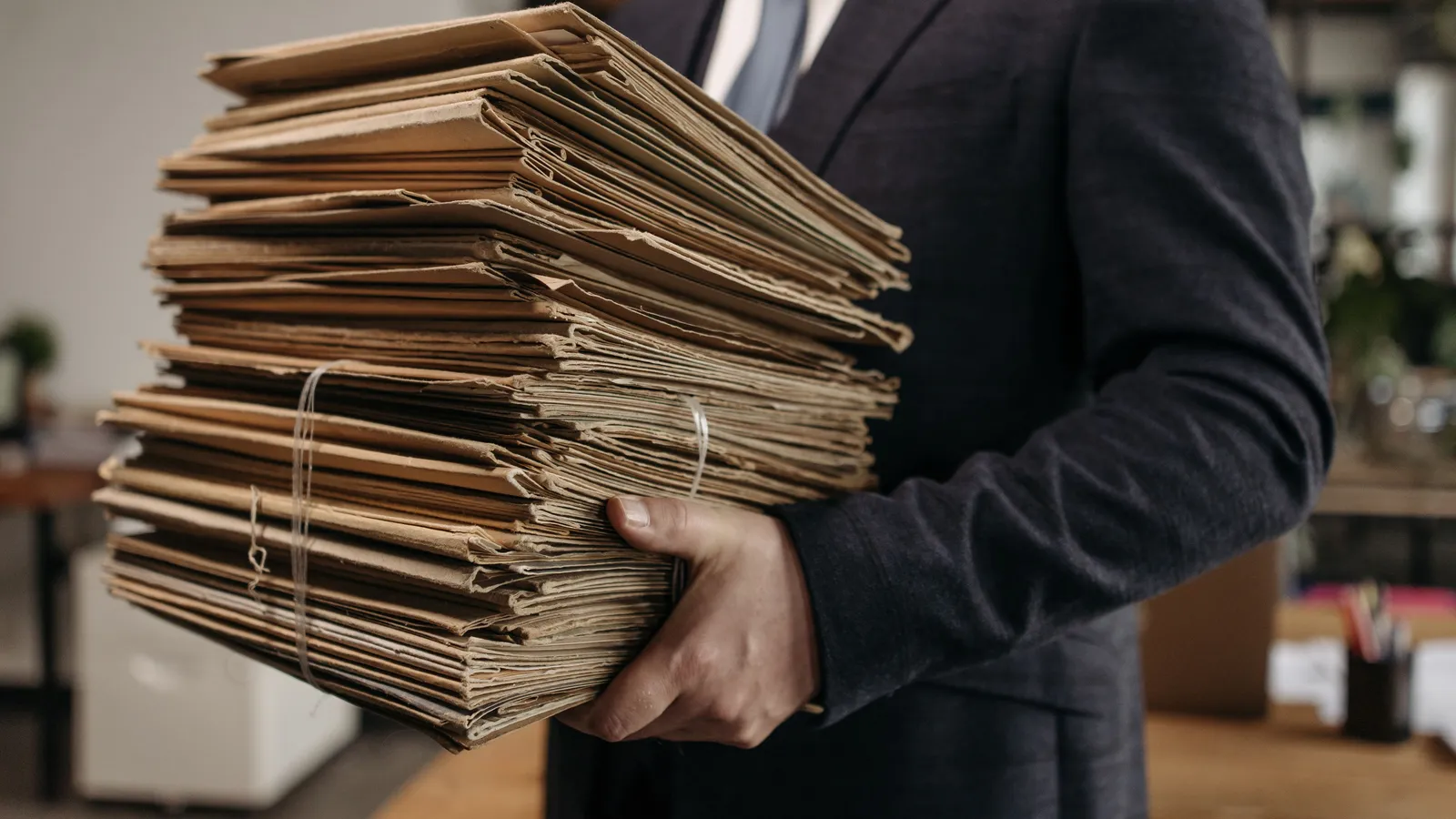 Consultante qualité transportant des dossiers de conformité Qualiopi dans un cabinet
