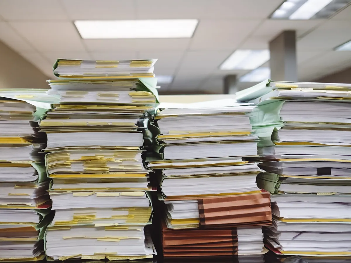 Documents administratifs et formulaire de bilan pédagogique et financier posés sur un bureau