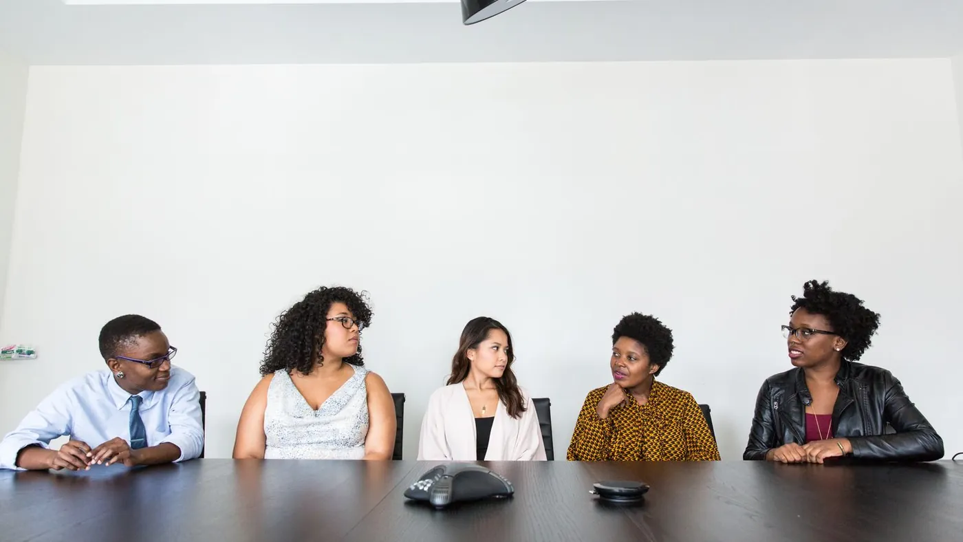 Équipe pluridisciplinaire en réunion de suivi de conformité dans un bureau professionnel