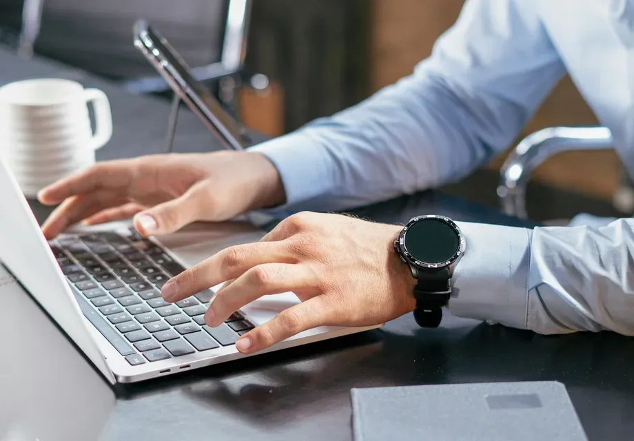 Formateur utilisant un outil d'IA générative sur ordinateur portable pour préparer des contenus de formation